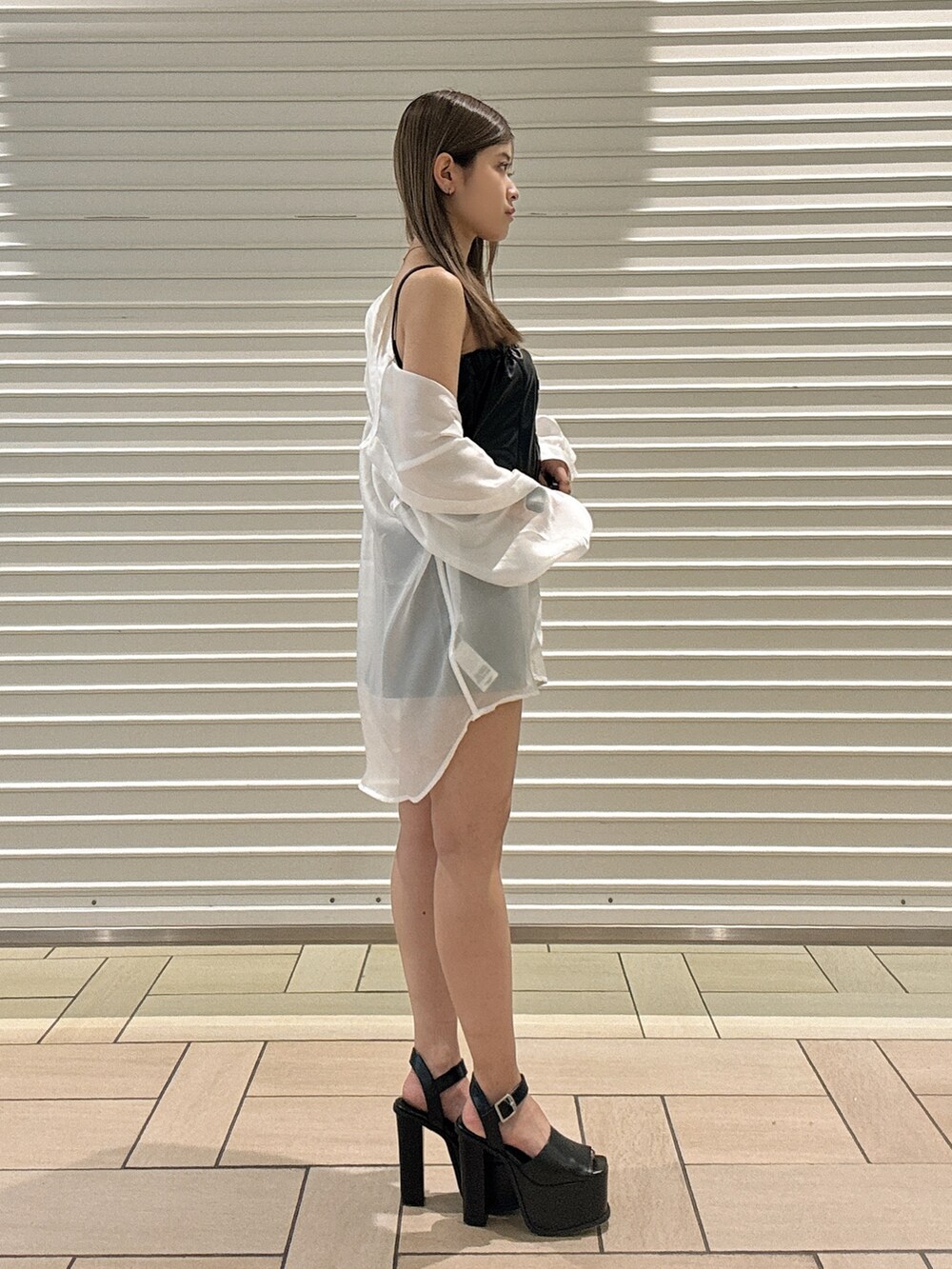 ホワイト系のシャツ/ブラウス、ブラック系のワンピース、ブラック系のサンダルを着用したレディースの春コーディネートの2枚目の写真