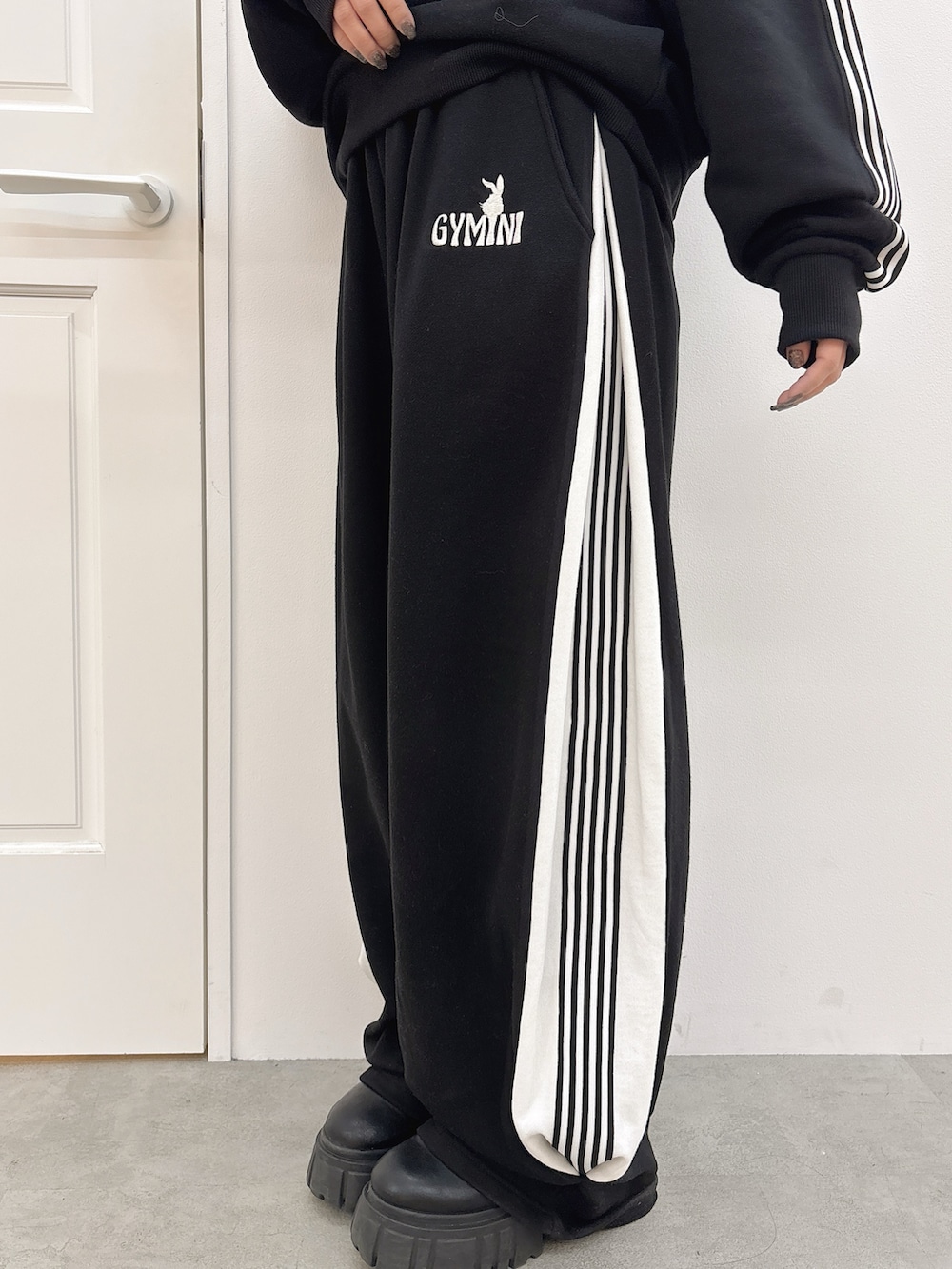 ブラック系のスウェットパンツ、ブラック系のスウェット、ブラック系のブーツを着用したレディースの冬コーディネートの6枚目の写真