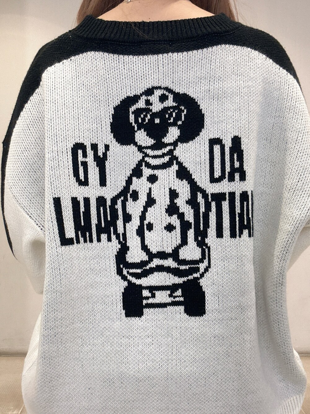 ホワイト系のニット/セーター、ブラック系のデニムパンツ、ブラック系のパンプスを着用したレディースの春コーディネートの7枚目の写真