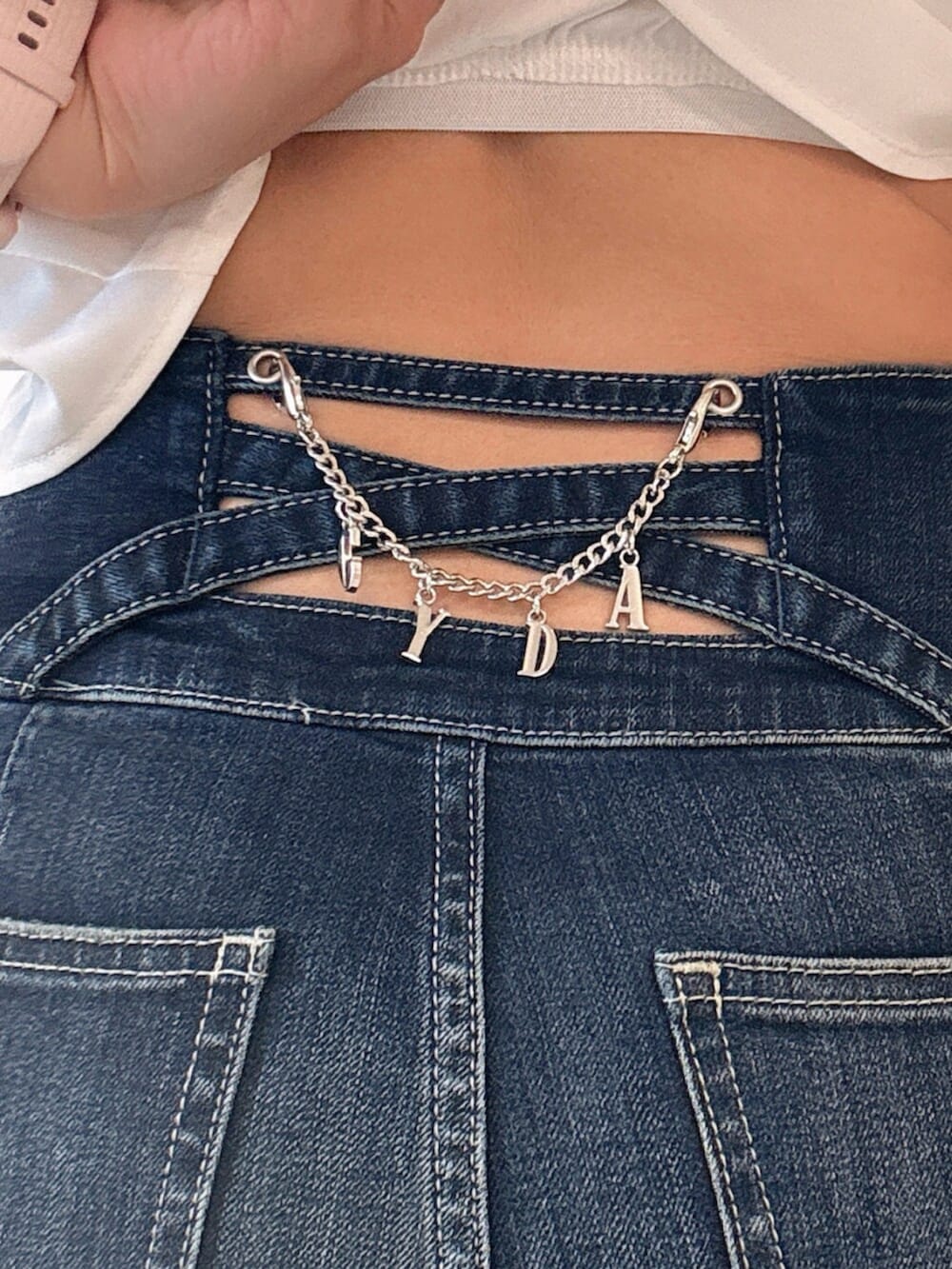 ブルー系のデニムパンツ、ブラック系のサンダル、ホワイト系のチューブトップを着用したレディースの夏コーディネートの6枚目の写真