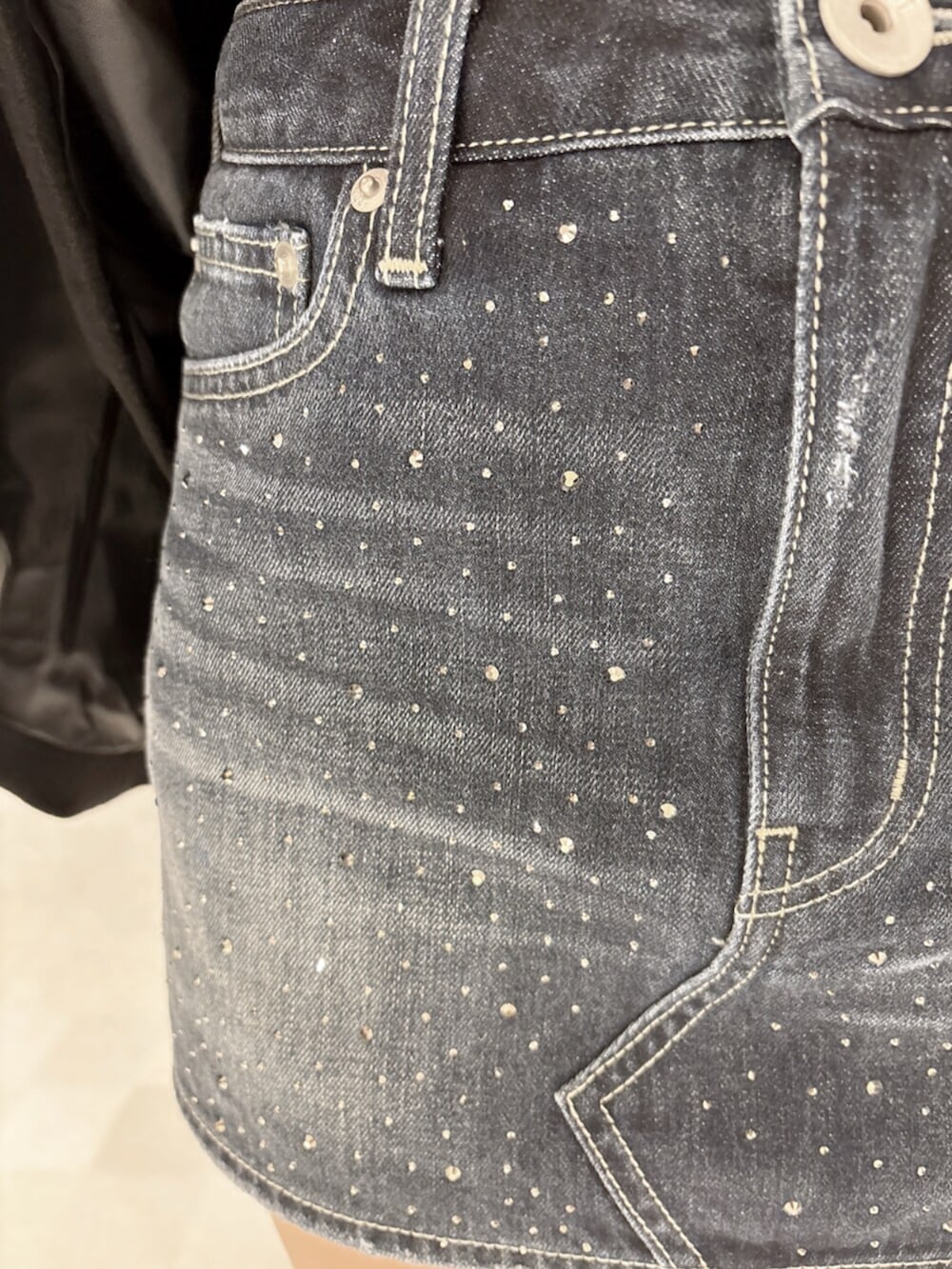 ブラック系のブーツ、ブラック系のTシャツ/カットソー、ブルー系のデニムスカートを着用したレディースの秋コーディネートの7枚目の写真