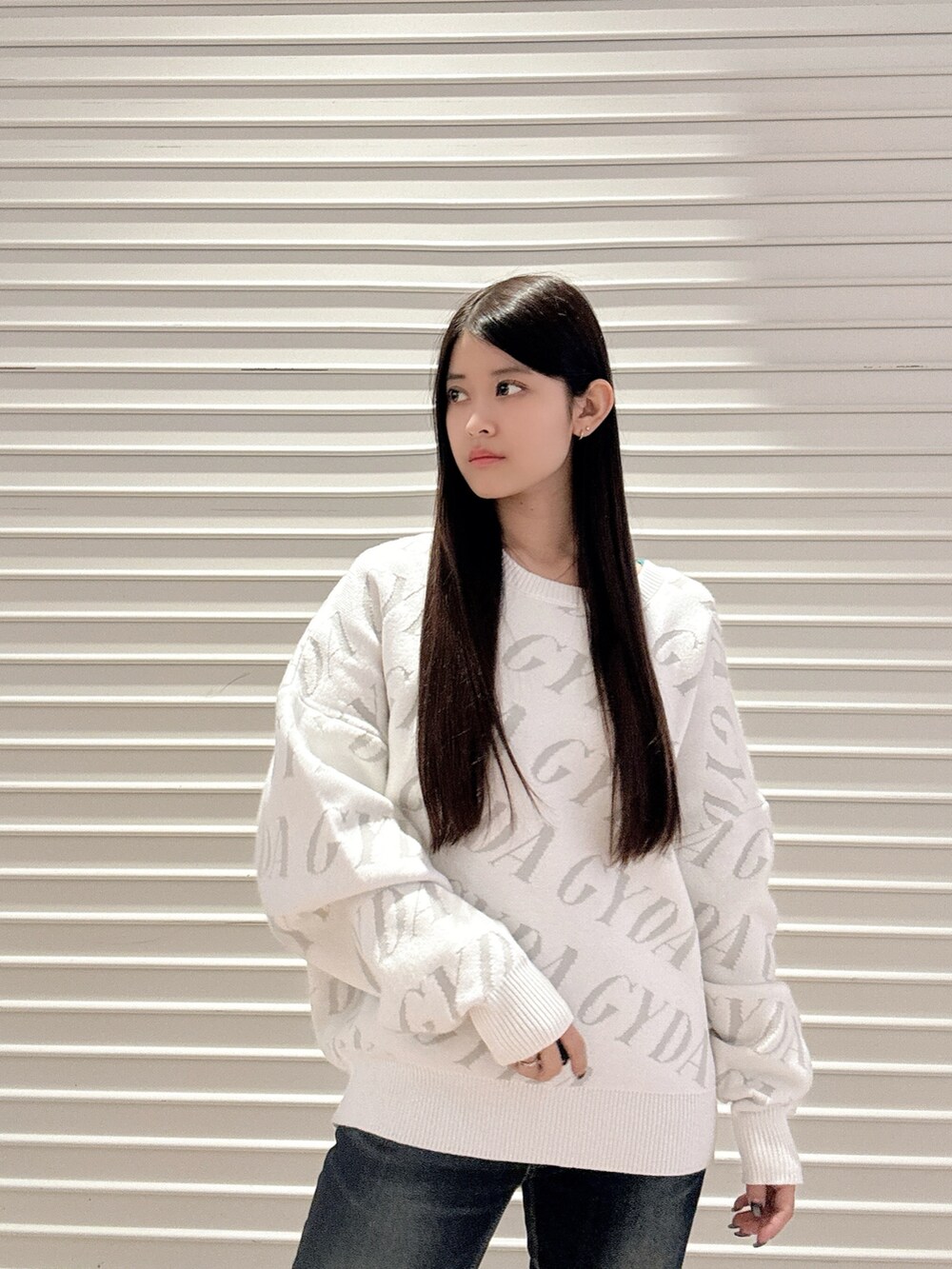 ホワイト系のニット/セーター、ブルー系のデニムパンツ、ブラック系のブーツを着用したレディースの秋コーディネートの5枚目の写真