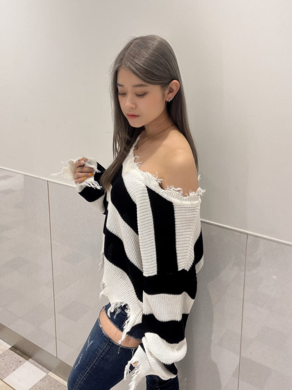 ブラック系のサンダル、ブルー系のデニムパンツ、ブラック系のニット/セーターを着用したレディースの夏コーディネートの5枚目の写真