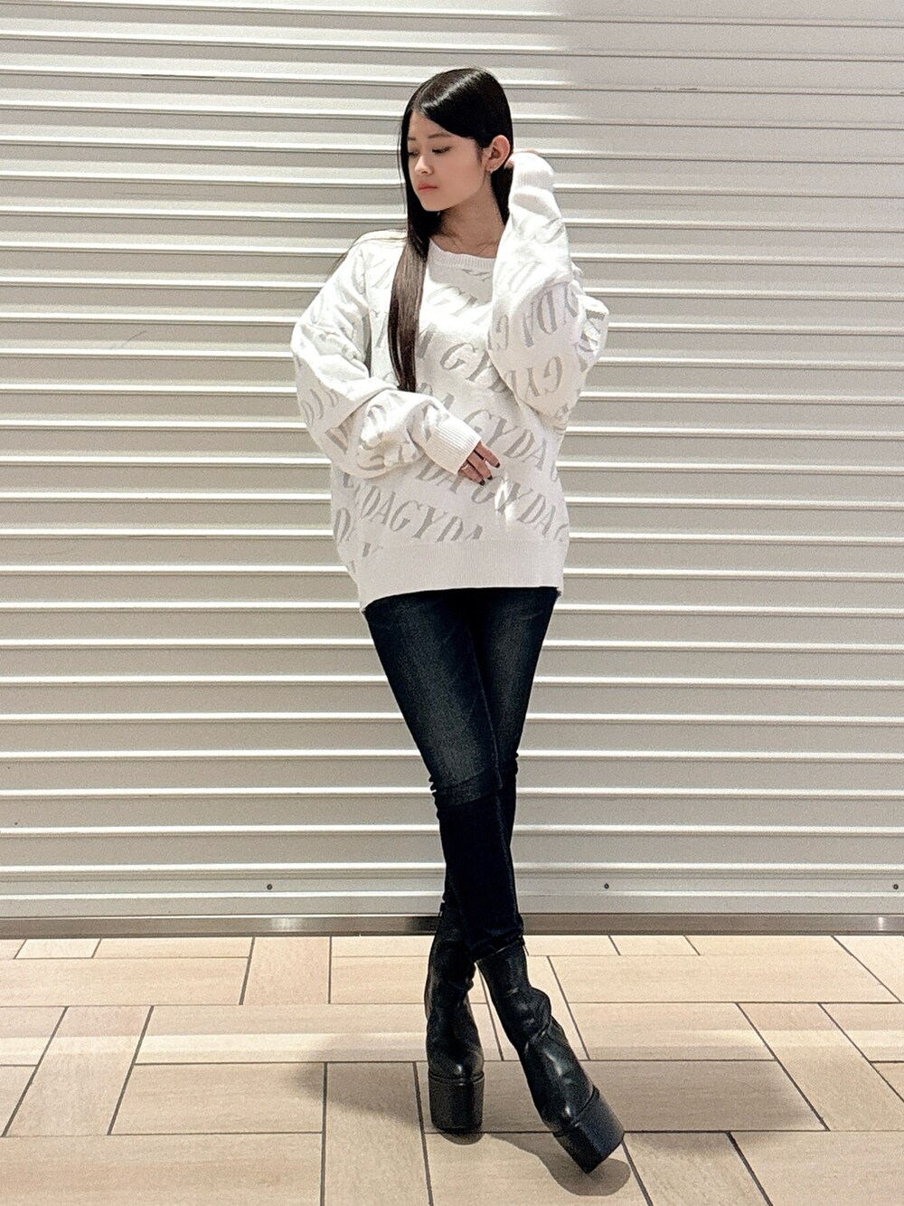 ホワイト系のニット/セーター、ブルー系のデニムパンツ、ブラック系のブーツを着用したレディースの秋コーディネートの2枚目の写真