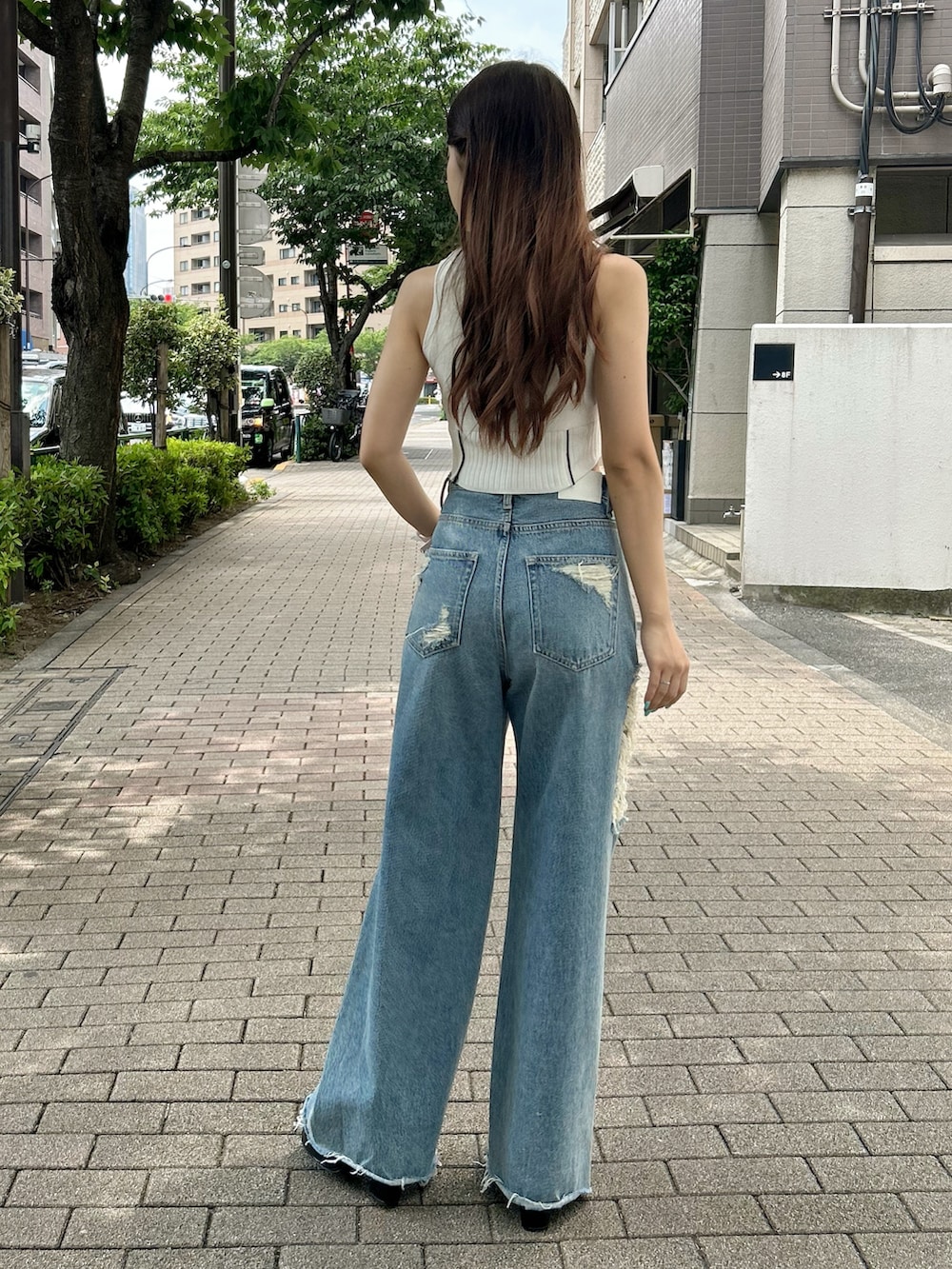 ホワイト系のニット/セーター、ブルー系のデニムパンツ、ブラック系のサンダルを着用したレディースの夏コーディネートの3枚目の写真