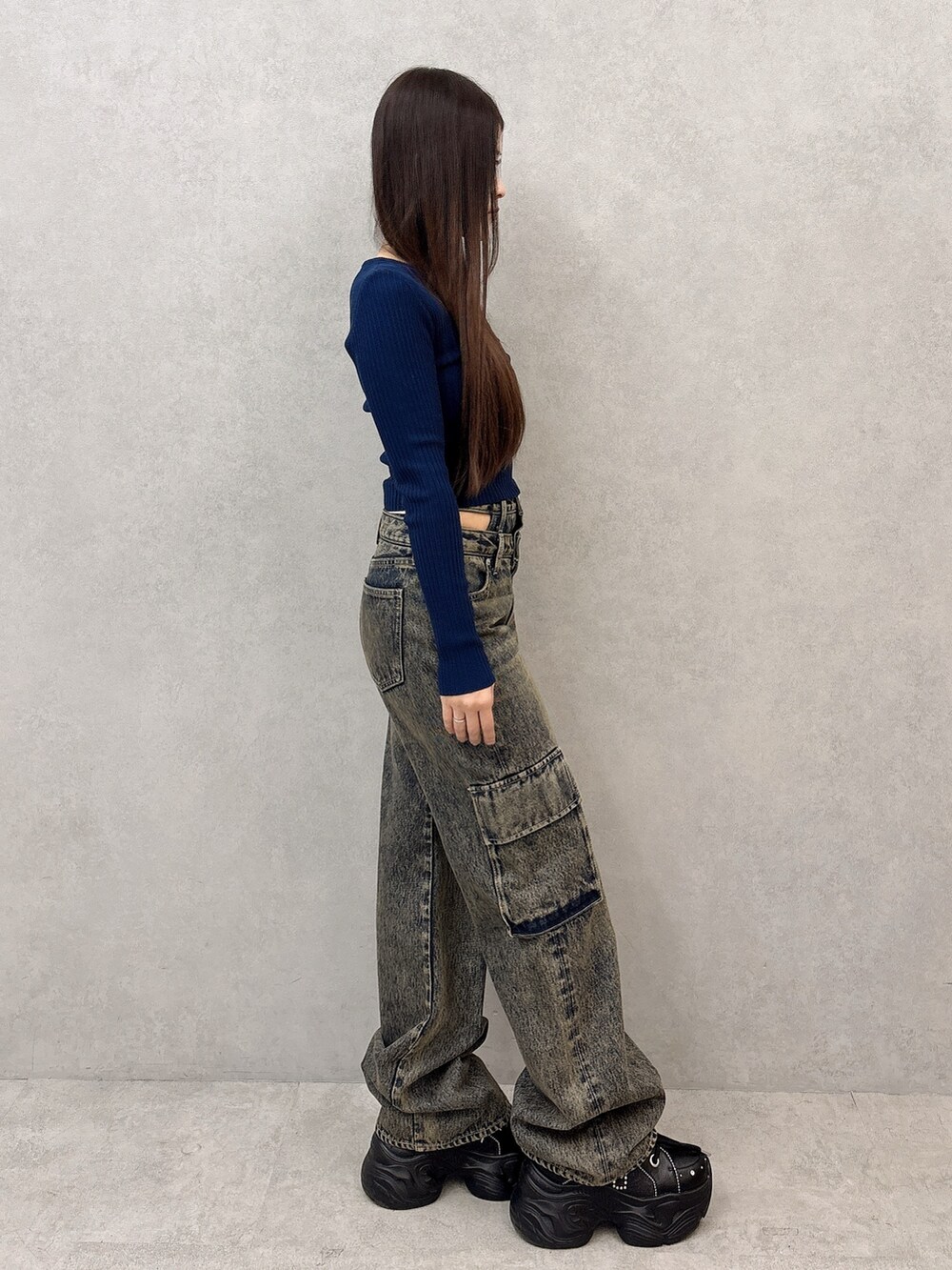 ブルー系のニット/セーター、ブルー系のデニムパンツ、ブラック系のスニーカーを着用したレディースの秋コーディネートの2枚目の写真