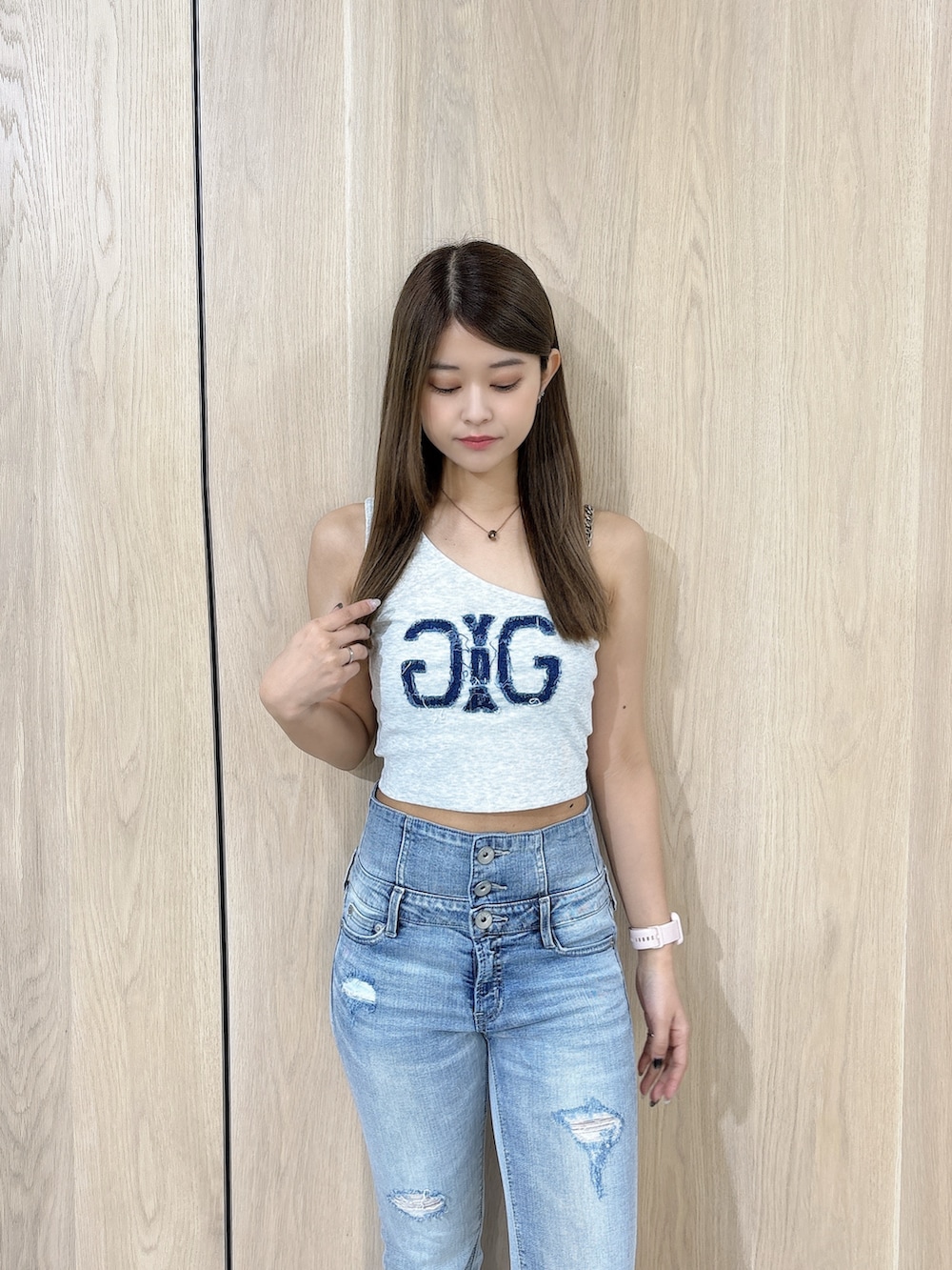 グレー系のタンクトップ、ブルー系のデニムパンツ、ホワイト系のサンダルを着用したレディースの夏コーディネートの4枚目の写真