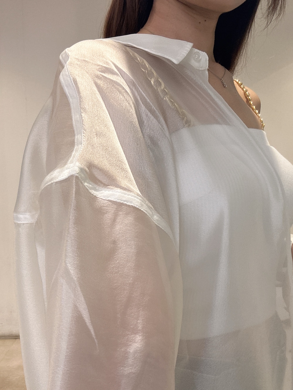 ホワイト系のキャミソール、ホワイト系のシャツ/ブラウス、ブルー系のデニムパンツを着用したレディースの夏コーディネートの6枚目の写真