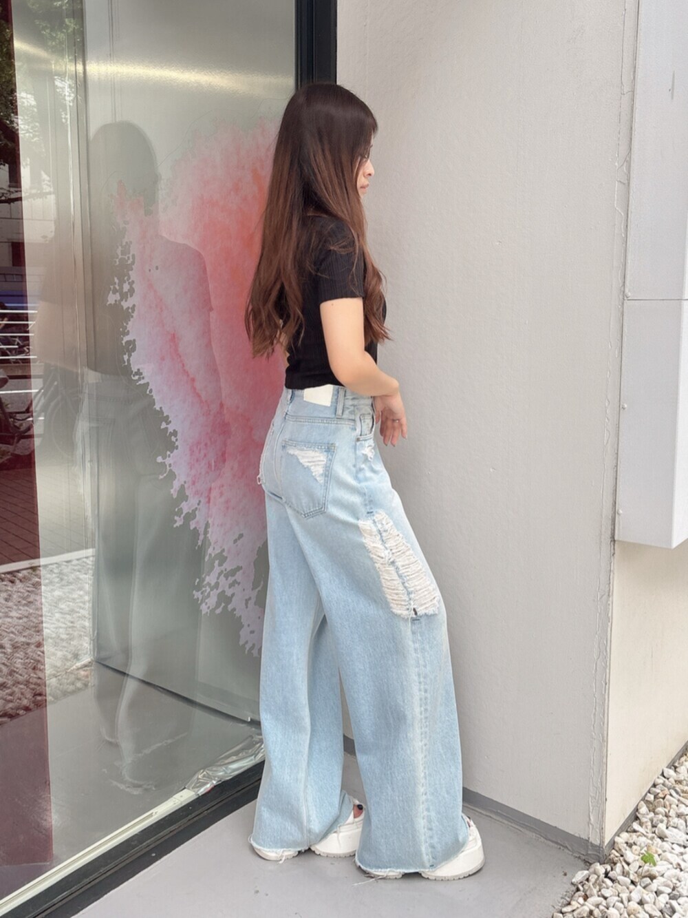 ホワイト系のサンダル、ブルー系のデニムパンツ、ブラック系のニット/セーターを着用したレディースの夏コーディネートの2枚目の写真