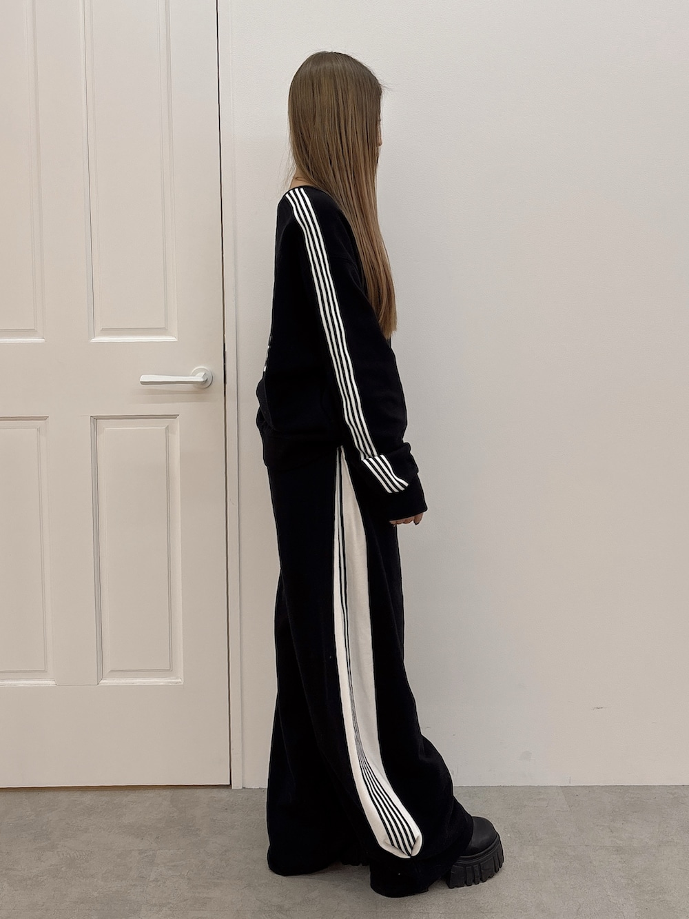 ブラック系のスウェットパンツ、ブラック系のスウェット、ブラック系のブーツを着用したレディースの冬コーディネートの2枚目の写真