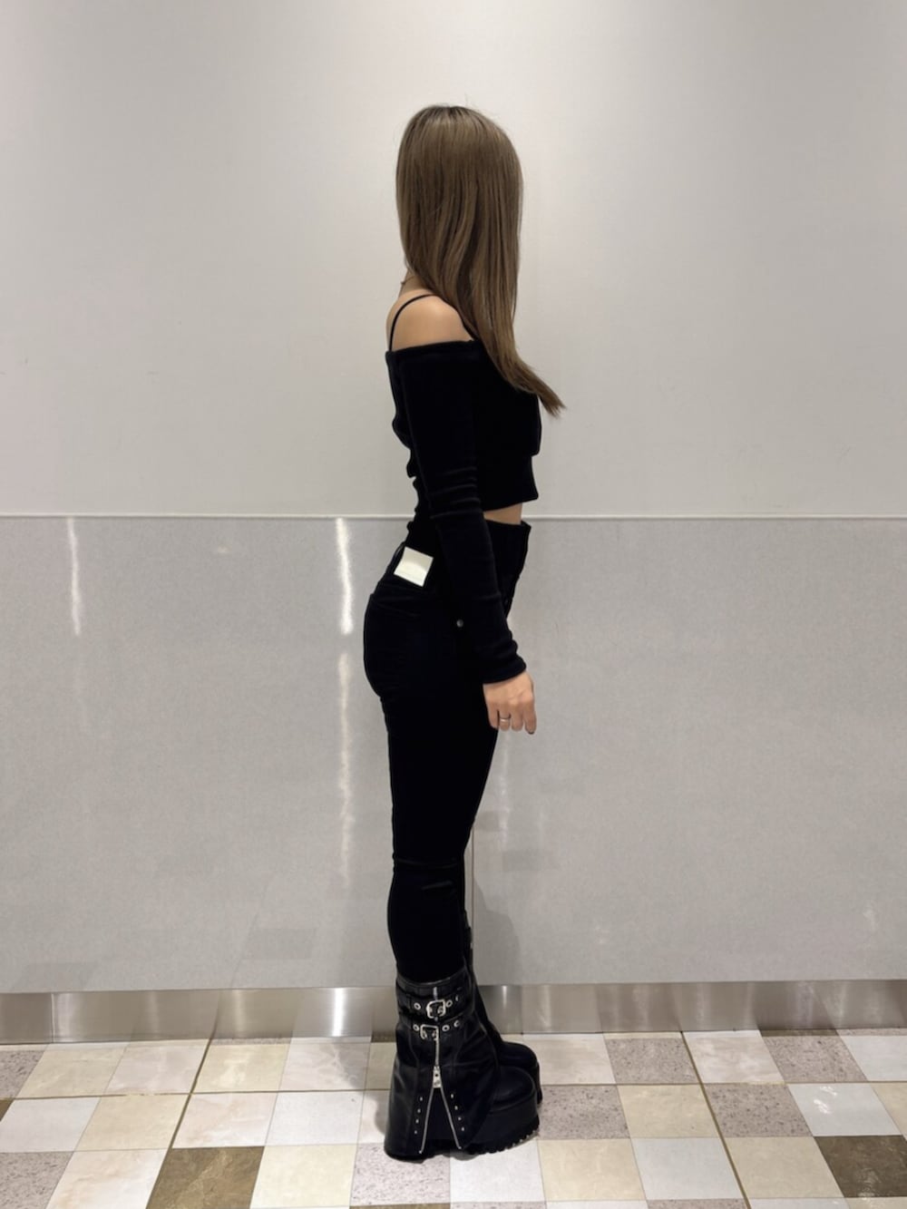 ブラック系のブーツ、ブラック系のTシャツ/カットソー、ブラック系のデニムパンツを着用したレディースの秋コーディネートの2枚目の写真