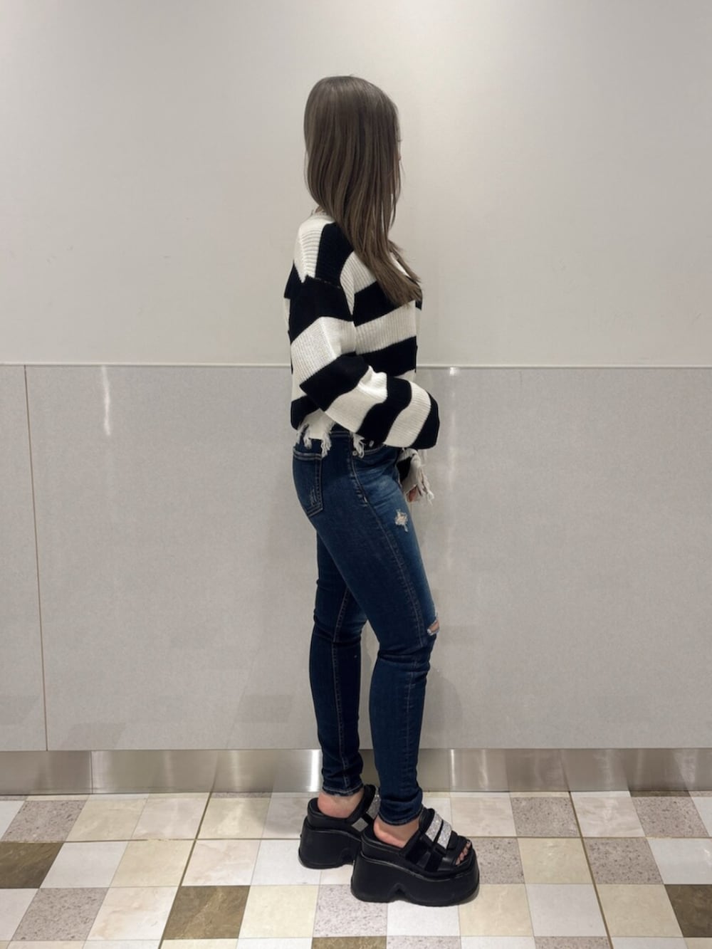 ブラック系のサンダル、ブルー系のデニムパンツ、ブラック系のニット/セーターを着用したレディースの夏コーディネートの2枚目の写真