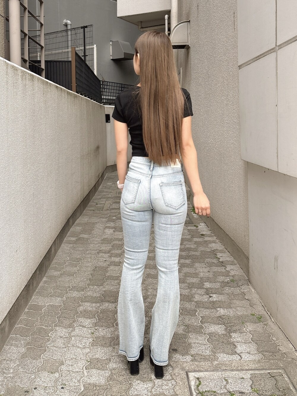 ブラック系のサンダル、ブラック系のTシャツ/カットソー、ブルー系のデニムパンツを着用したレディースの春コーディネートの3枚目の写真