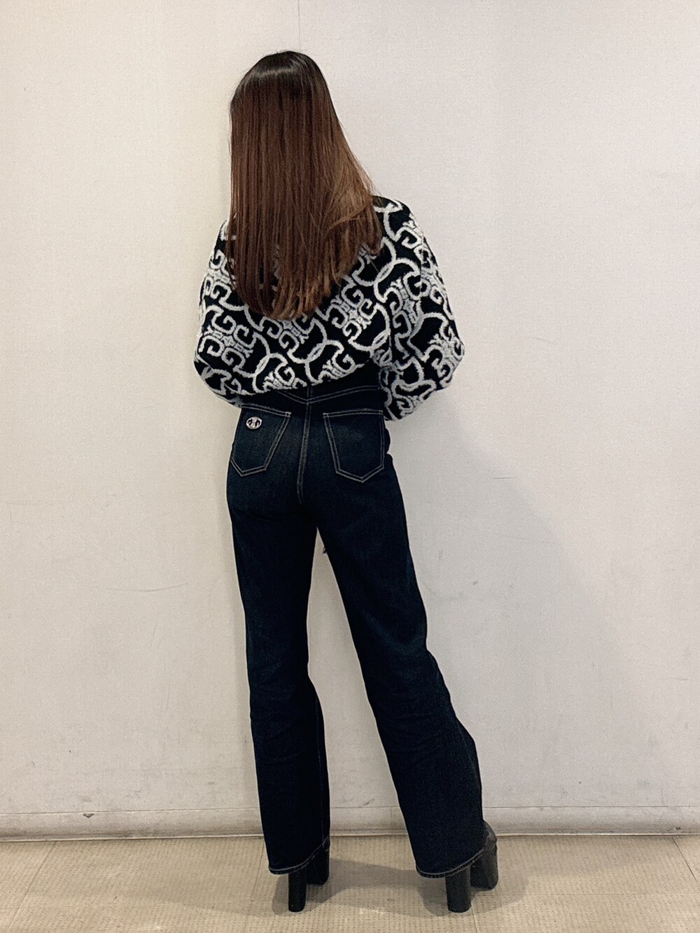 ブラック系のニット/セーター、ブルー系のデニムパンツ、ブラック系のブーツを着用したレディースの冬コーディネートの3枚目の写真