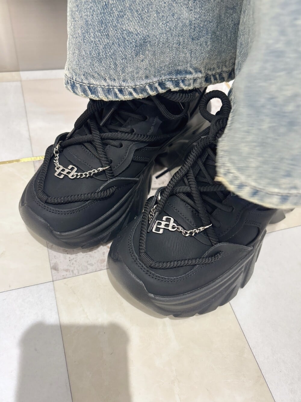 ブラック系のスニーカー、グレー系のパーカー、ホワイト系のTシャツ/カットソーを着用したレディースの夏コーディネートの8枚目の写真