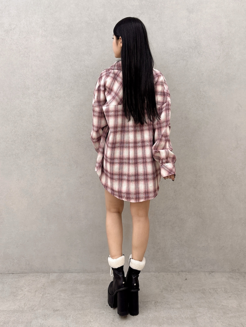 ホワイト系のニット/セーター、ピンク系のシャツ/ブラウス、ブラック系のスカートを着用したレディースの冬コーディネートの3枚目の写真