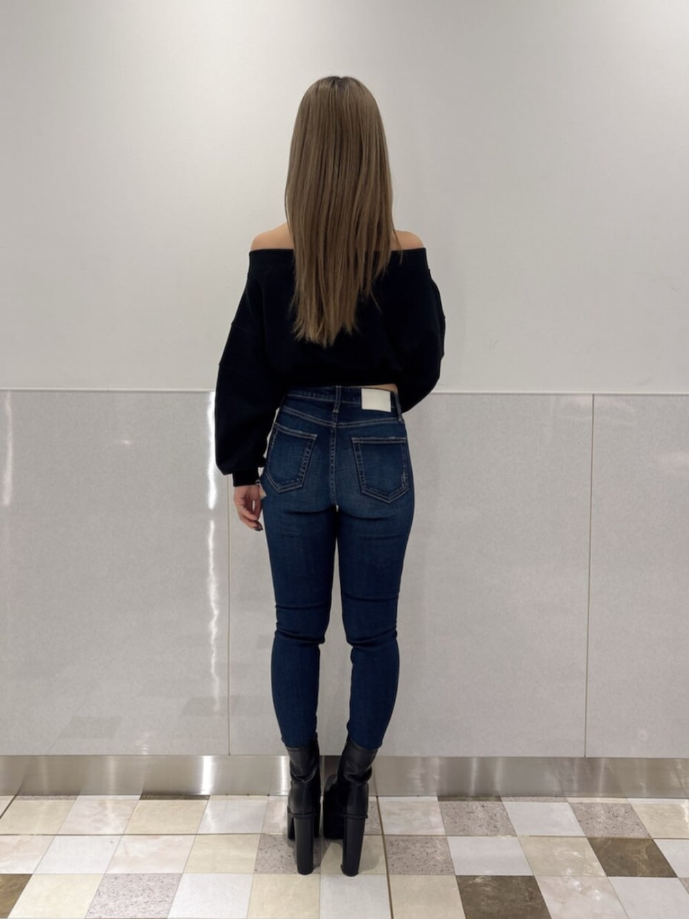 ブルー系のデニムパンツ、ブラック系のブーツ、ブラック系のTシャツ/カットソーを着用したレディースの秋コーディネートの3枚目の写真