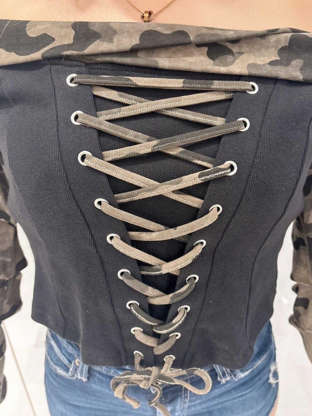 ブルー系のデニムパンツ、ブラック系のブーツ、グリーン系のTシャツ/カットソーを着用したレディースの秋コーディネートの5枚目の写真