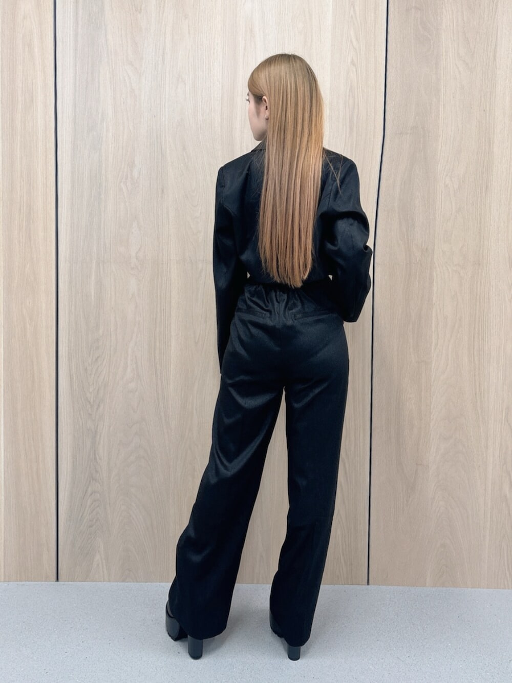 ホワイト系のキャミソール、ブラック系のテーラードジャケット、ブラック系のその他パンツを着用したレディースの春コーディネートの3枚目の写真