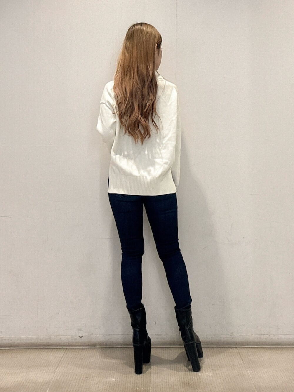 ブラック系のブーツ、ブルー系のデニムパンツ、ホワイト系のニット/セーターを着用したレディースの春コーディネートの3枚目の写真