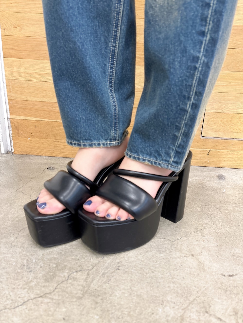 ブラック系のニット/セーター、ブルー系のデニムパンツ、ブラック系のサンダルを着用したレディースの夏コーディネートの7枚目の写真