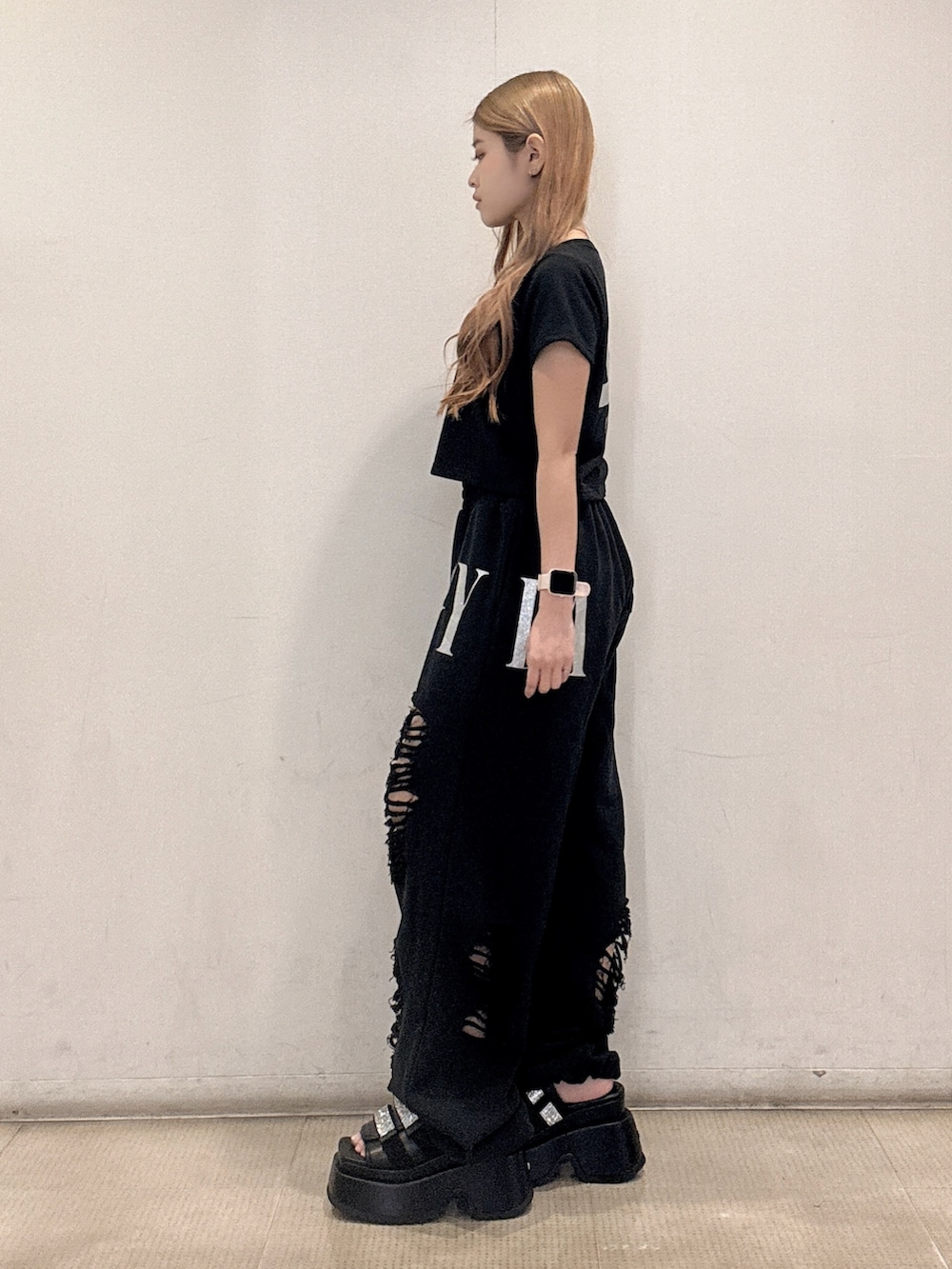 ブラック系のTシャツ/カットソー、ブラック系のスウェットパンツ、ブラック系のサンダルを着用したレディースの春コーディネートの2枚目の写真