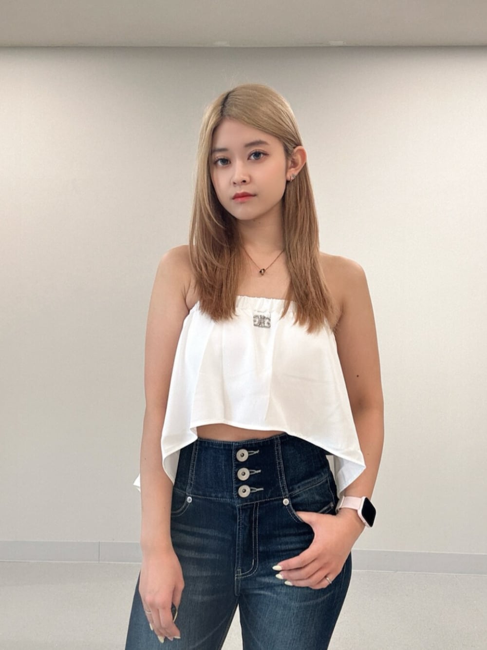 ブルー系のデニムパンツ、ブラック系のサンダル、ホワイト系のチューブトップを着用したレディースの夏コーディネートの4枚目の写真