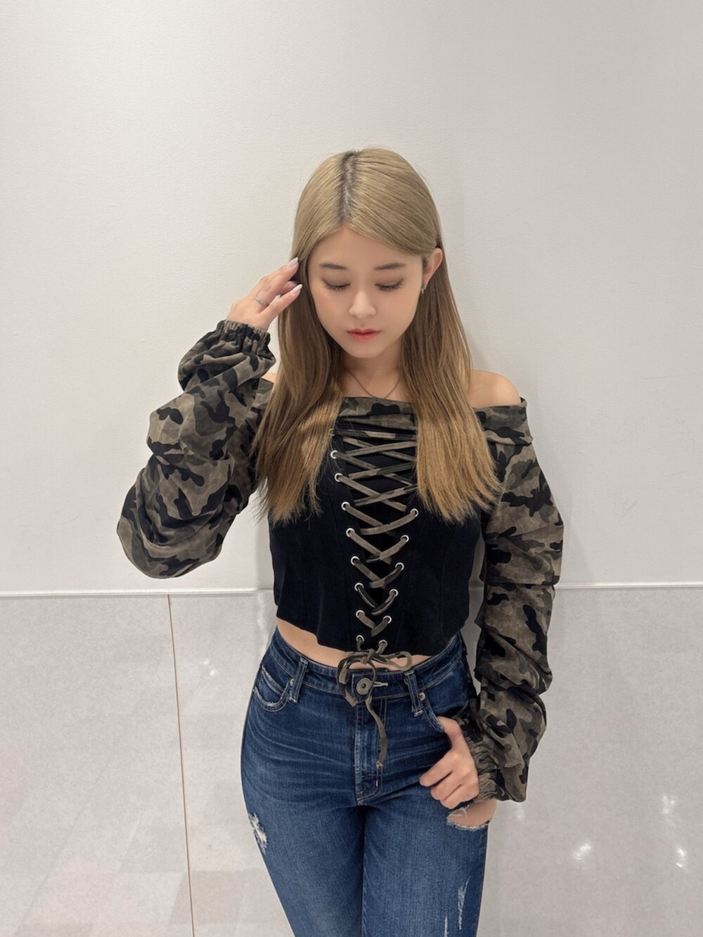 ブルー系のデニムパンツ、ブラック系のブーツ、グリーン系のTシャツ/カットソーを着用したレディースの秋コーディネートの4枚目の写真