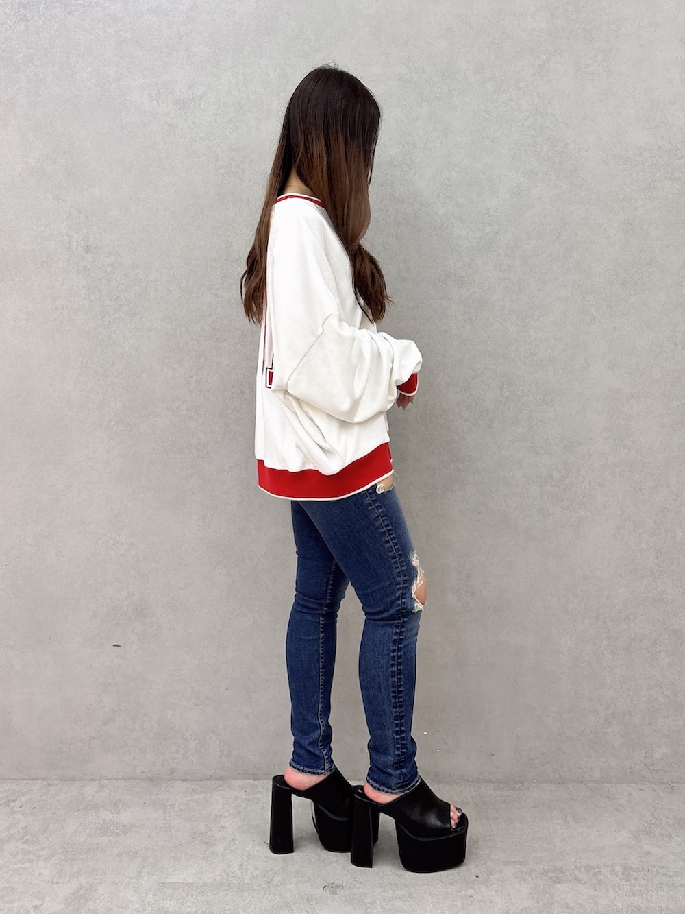 ホワイト系のスウェット、ブルー系のデニムパンツ、ブラック系のサンダルを着用したレディースの夏コーディネートの2枚目の写真