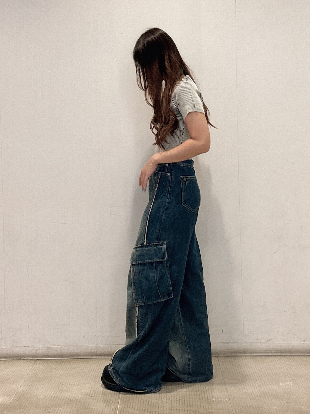 ホワイト系のニット/セーター、ブルー系のつなぎ/オールインワン、ブラック系のスニーカーを着用したレディースの夏コーディネートの2枚目の写真