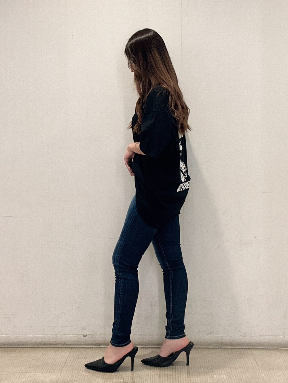 ブラック系のTシャツ/カットソー、ブルー系のデニムパンツ、ブラック系のパンプスを着用したレディースの春コーディネートの2枚目の写真
