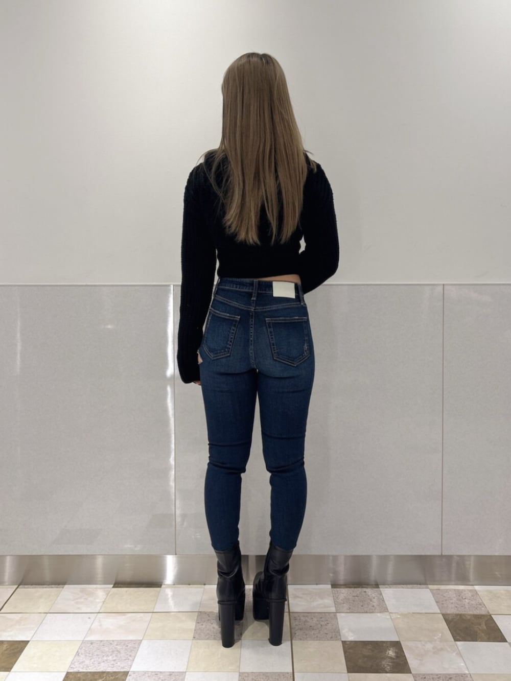 ブルー系のデニムパンツ、ブラック系のブーツ、ブラック系のニット/セーターを着用したレディースの秋コーディネートの3枚目の写真