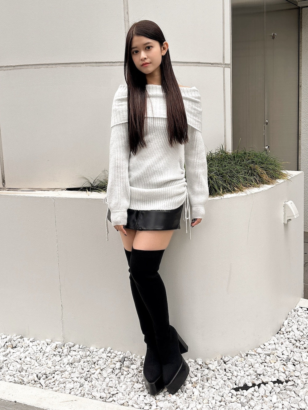 ホワイト系のチュニック、ブラック系のスカート、ブラック系のブーツを着用したレディースの秋コーディネートの2枚目の写真