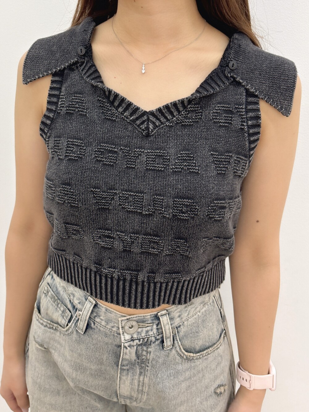 ブラック系のニット/セーター、ブルー系のデニムパンツ、ブラック系のバックパック/リュックを着用したレディースの夏コーディネートの6枚目の写真