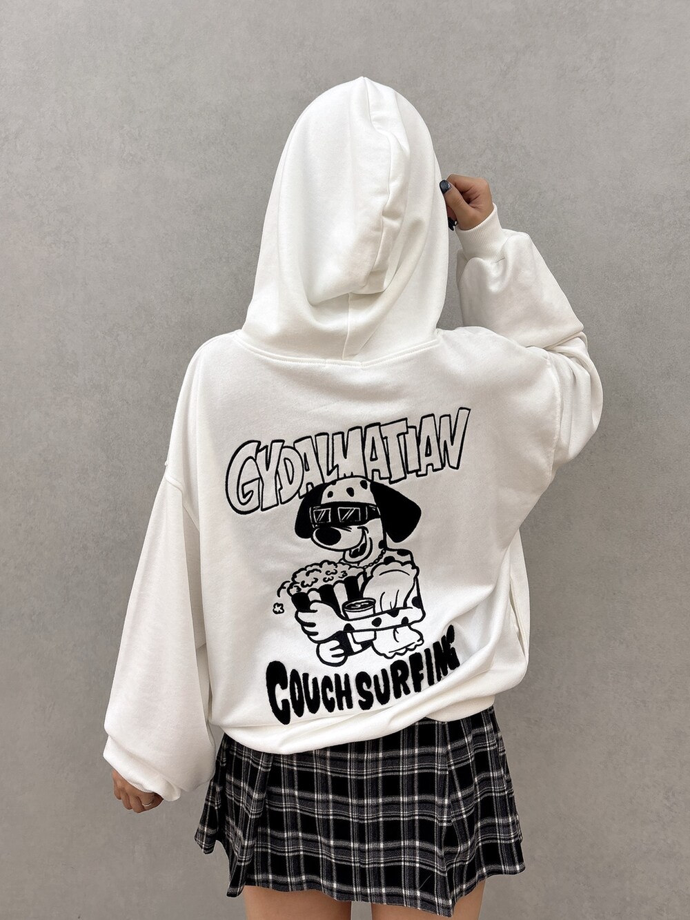 ホワイト系のパーカー、ブラック系のスカート、ブラック系のブーツを着用したレディースの秋コーディネートの5枚目の写真