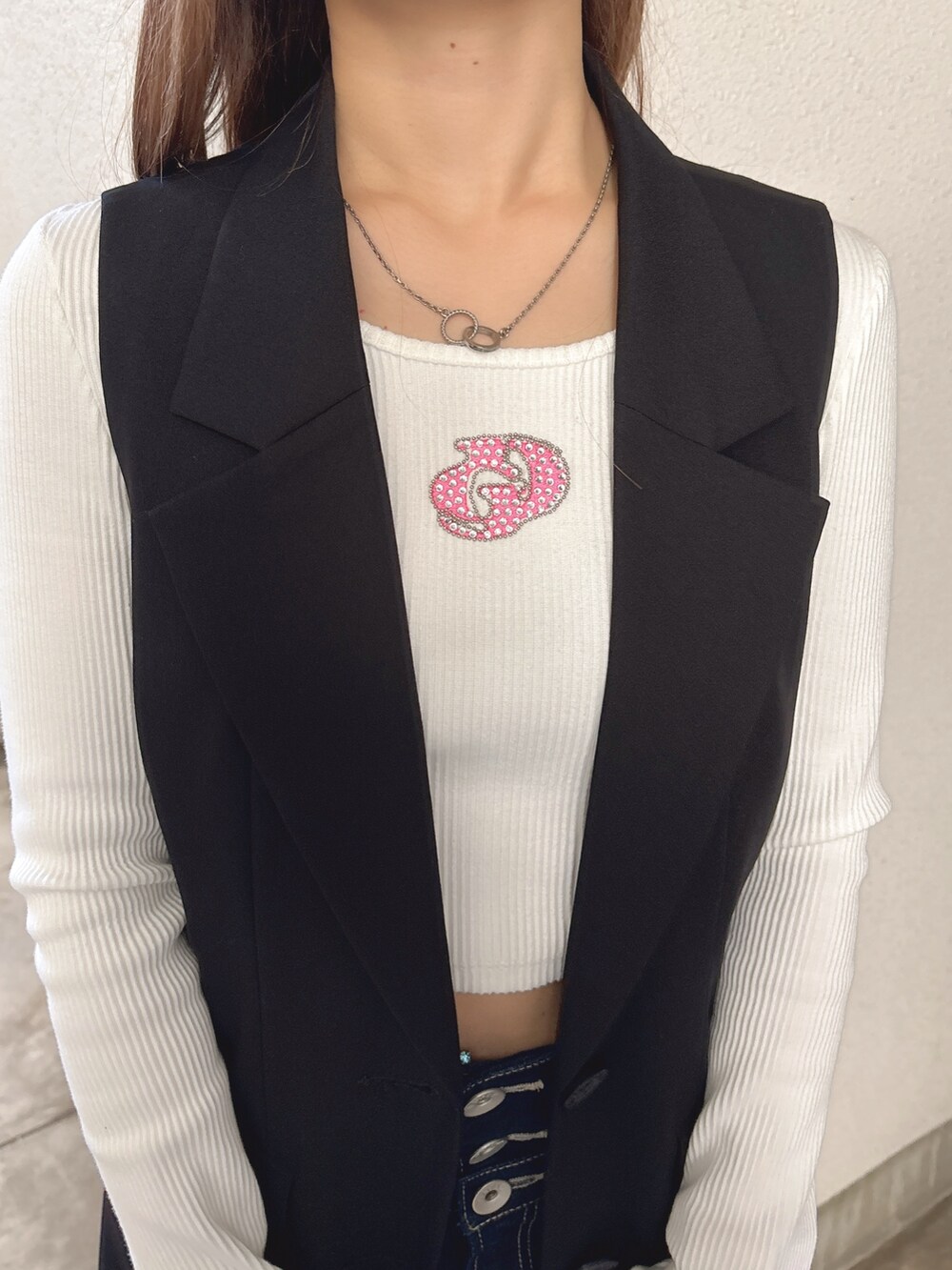 ホワイト系のTシャツ/カットソー、ブラック系のベスト、ブルー系のデニムパンツを着用したレディースの春コーディネートの5枚目の写真