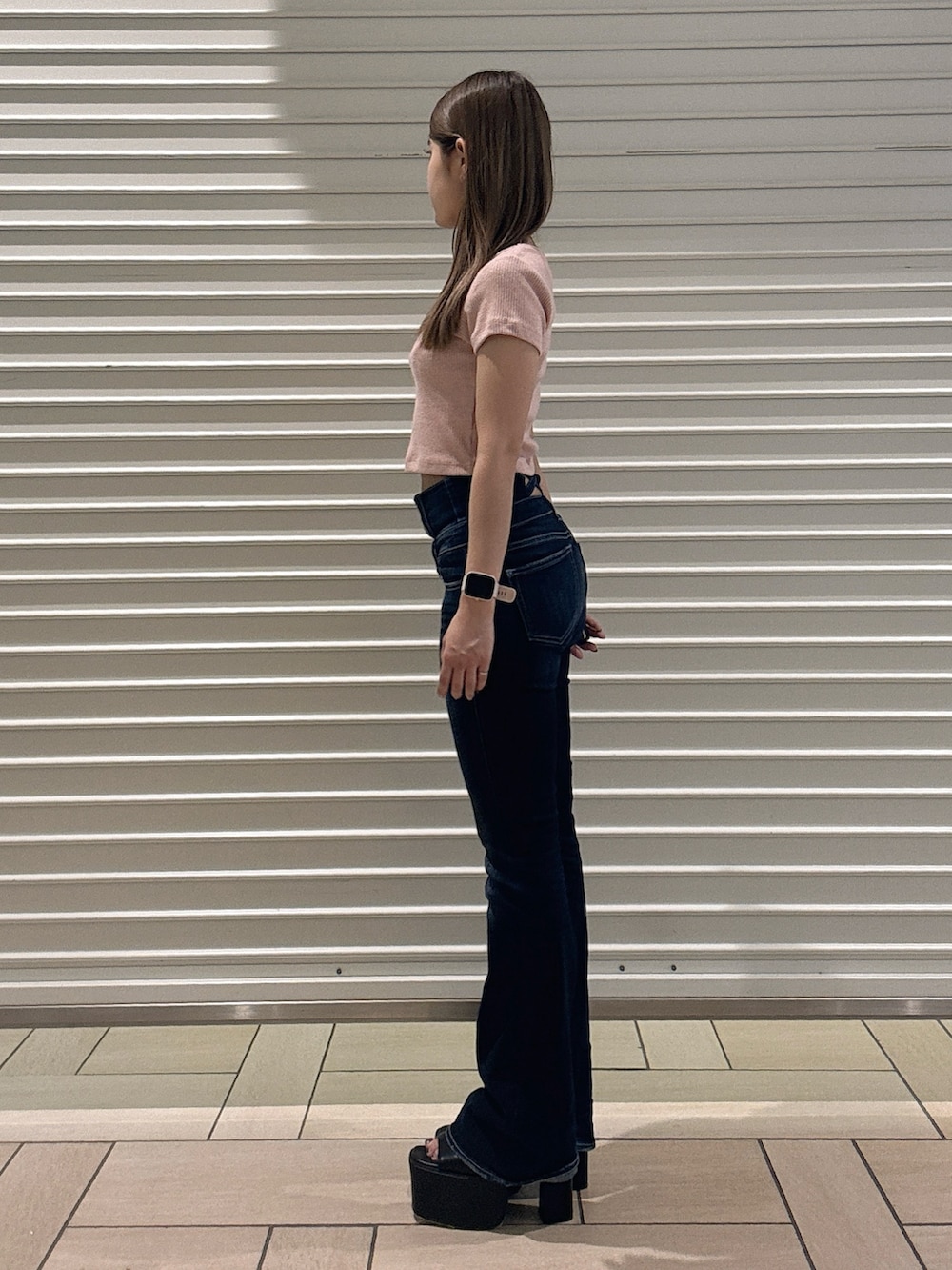 ピンク系のTシャツ/カットソー、ブルー系のデニムパンツ、ブラック系のサンダルを着用したレディースの春コーディネートの2枚目の写真
