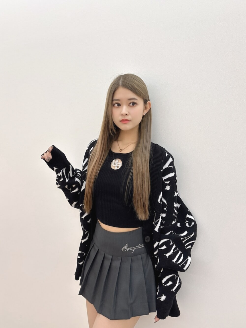ブラック系のブーツ、ブラック系のTシャツ/カットソー、グレー系のスカートを着用したレディースの冬コーディネートの6枚目の写真