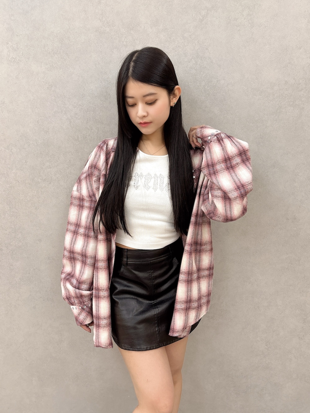 ホワイト系のニット/セーター、ピンク系のシャツ/ブラウス、ブラック系のスカートを着用したレディースの冬コーディネートの4枚目の写真