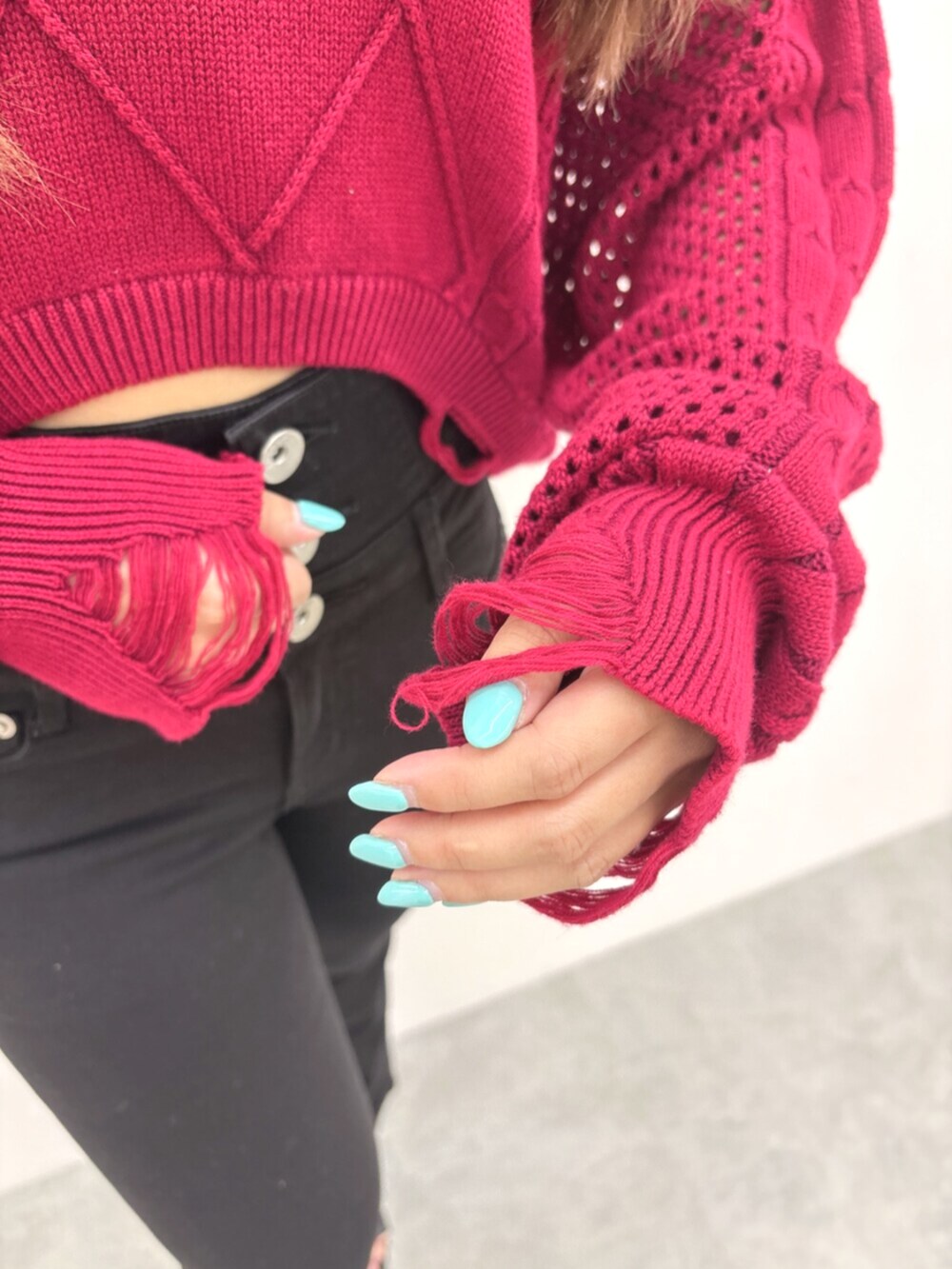 ブラック系のサンダル、レッド系のニット/セーター、ブラック系のデニムパンツを着用したレディースの夏コーディネートの6枚目の写真