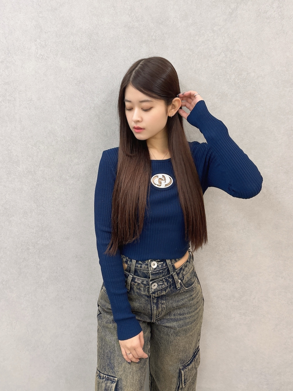 ブルー系のニット/セーター、ブルー系のデニムパンツ、ブラック系のスニーカーを着用したレディースの秋コーディネートの4枚目の写真