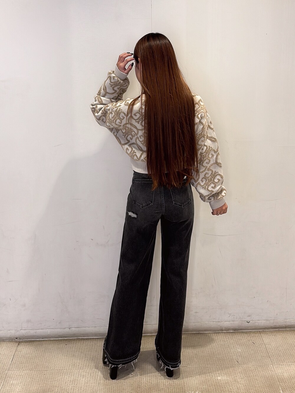 ホワイト系のニット/セーター、ブラック系のデニムパンツ、ブラック系のブーツを着用したレディースの秋コーディネートの3枚目の写真