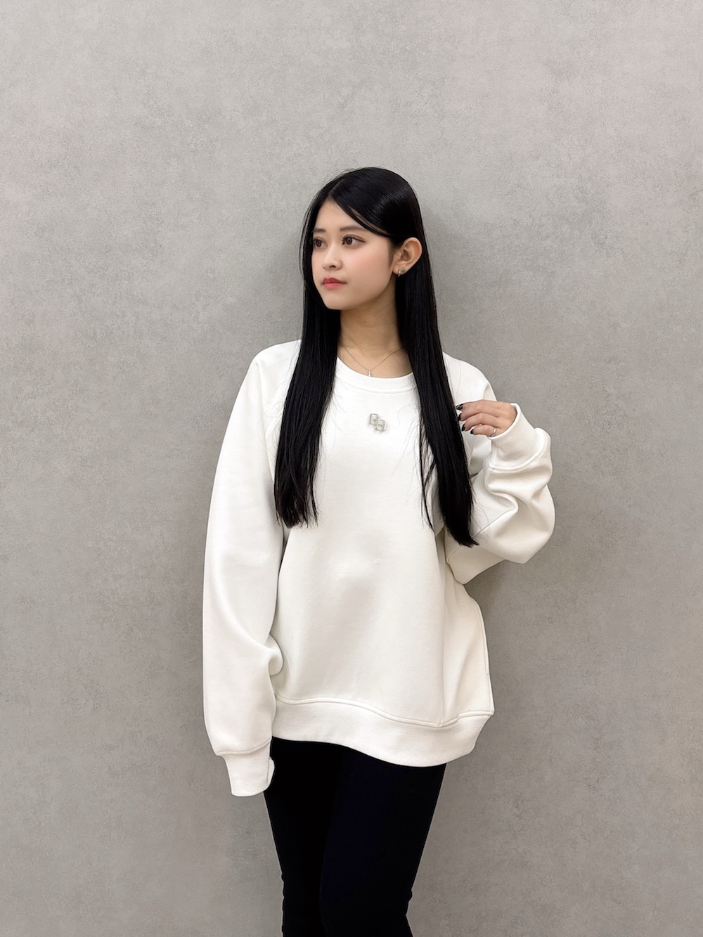 ホワイト系のスウェット、ブラック系のデニムパンツ、ブラック系のブーツを着用したレディースの冬コーディネートの4枚目の写真