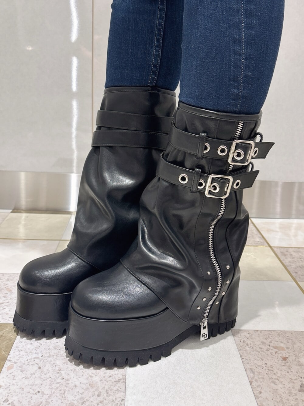 ブルー系のデニムパンツ、ブラック系のキャミソール、ブラック系のブーツを着用したレディースの夏コーディネートの6枚目の写真
