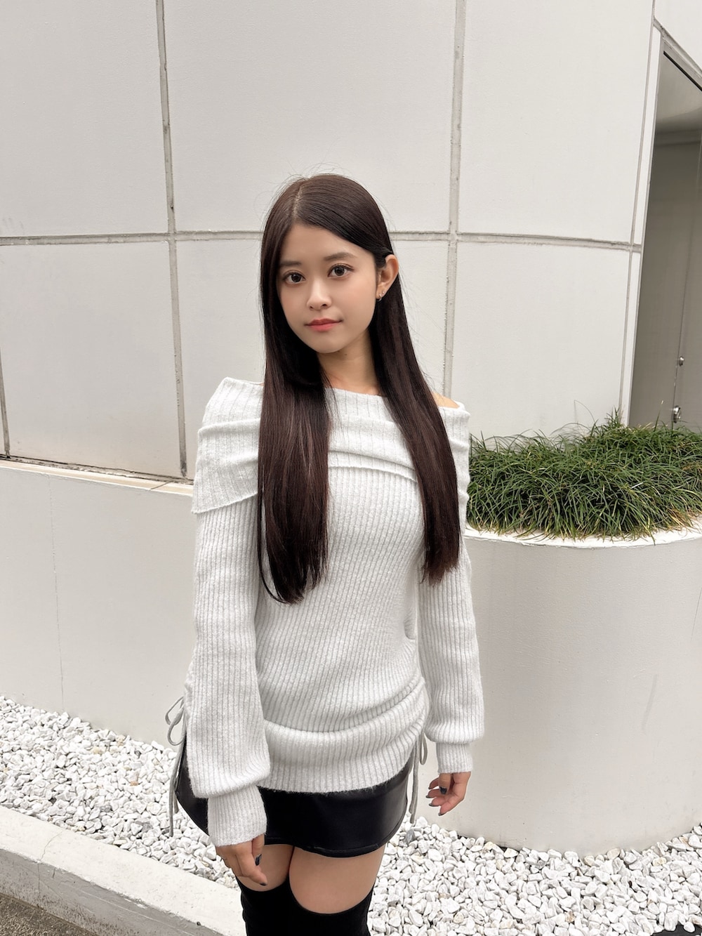 ホワイト系のチュニック、ブラック系のスカート、ブラック系のブーツを着用したレディースの秋コーディネートの5枚目の写真