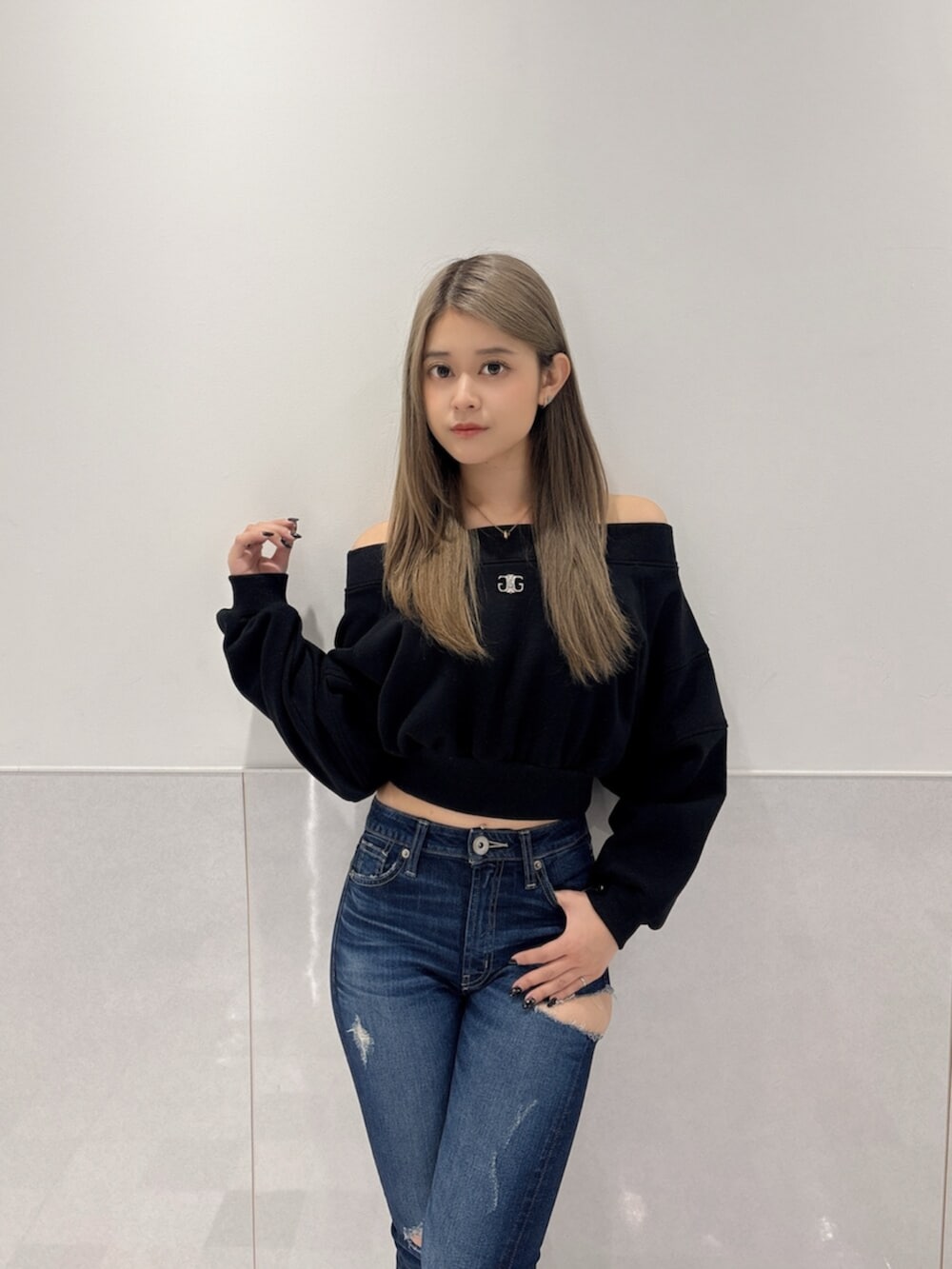 ブルー系のデニムパンツ、ブラック系のブーツ、ブラック系のTシャツ/カットソーを着用したレディースの秋コーディネートの4枚目の写真