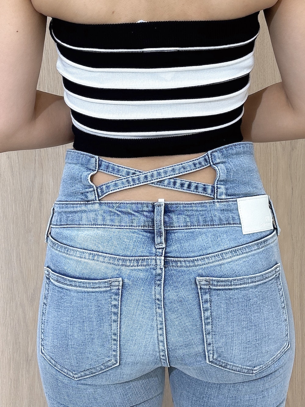ブラック系のニット/セーター、ブルー系のデニムパンツ、ホワイト系のサンダルを着用したレディースの夏コーディネートの6枚目の写真