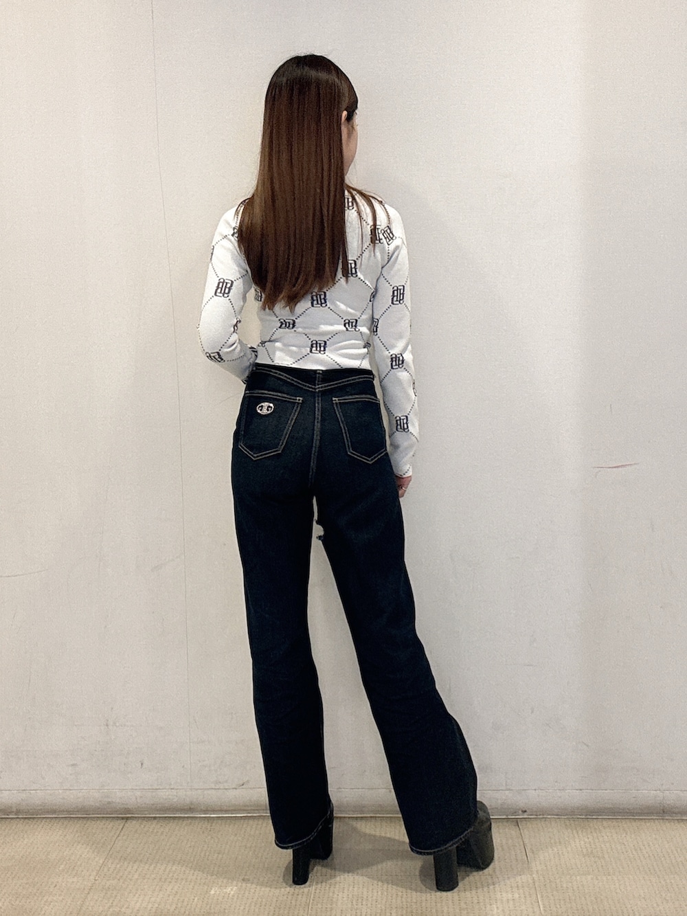 ホワイト系のニット/セーター、ブルー系のデニムパンツ、ブラック系のブーツを着用したレディースの冬コーディネートの3枚目の写真