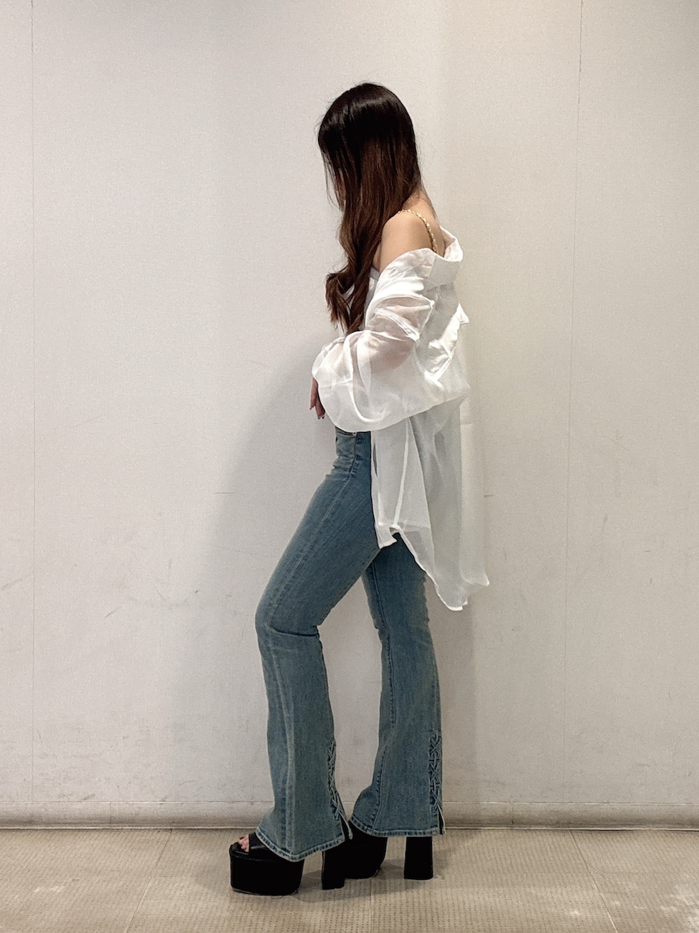 ホワイト系のキャミソール、ホワイト系のシャツ/ブラウス、ブルー系のデニムパンツを着用したレディースの夏コーディネートの2枚目の写真