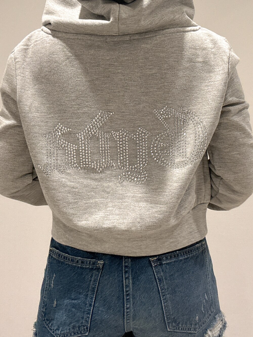 ブラック系のキャミソール、グレー系のパーカー、ブルー系のデニムパンツを着用したレディースの春コーディネートの6枚目の写真